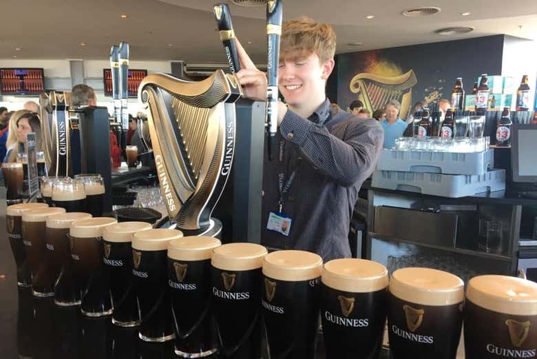 Un cameriere mentre serve una pimta di Guinness